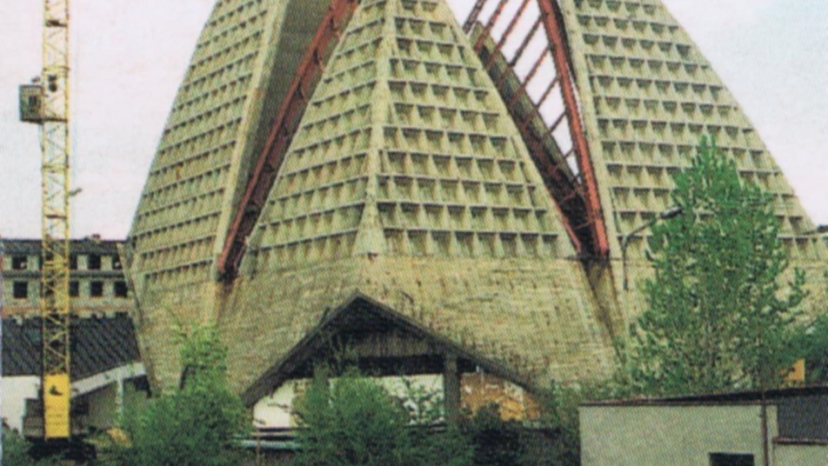 Budujący się kościół z charakterystyczną żelbetową konstrukcją łupin, zwaną potocznie _gofrem_. Pocztówka z 1997 r.